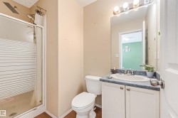 Bathroom featuring a shower with frosted glass enclosure, white vanity with blue countertop, oval drop-in sink, and a mirrored medicine cabinet with vanity lighting - 