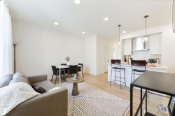 Open-concept living space featuring wood-finish flooring, recessed lighting, and a kitchen island with pendant lighting - 