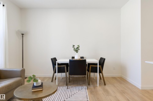 Open-concept living space featuring wood-finish flooring, white walls, and bright natural light from a window - 323 Rankin Drive, St. Albert, AB - Indoor Photo Showing Dining Room