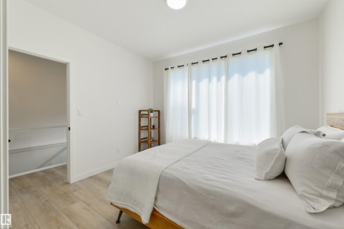 Bright room featuring wood-finish flooring and white walls - 323 Rankin Drive, St. Albert, AB - Indoor Photo Showing Bedroom