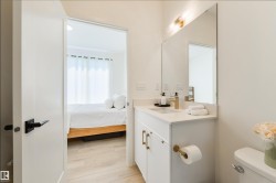 Modern bathroom vanity with a single basin, quartz countertop, and gold-finish fixtures - 