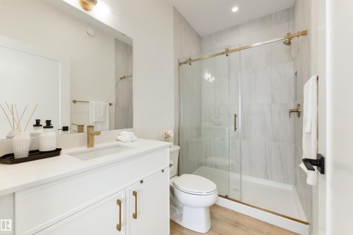 Bathroom featuring a white vanity with gold-finish hardware, a rectangular undermount sink, and a white countertop - 323 Rankin Drive, St. Albert, AB - Indoor Photo Showing Bathroom