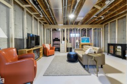 Unfinished basement featuring exposed wood framing, concrete walls, and overhead utility lines - 