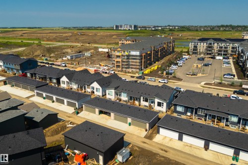 Newly constructed residential properties featuring dark shingled roofs and a mix of light and dark exterior finishes - 323 Rankin Drive, St. Albert, AB - Outdoor With View