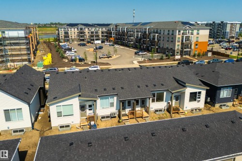 Row of modern townhomes featuring white and dark siding, private decks, and multiple window styles - 323 Rankin Drive, St. Albert, AB - Outdoor With View