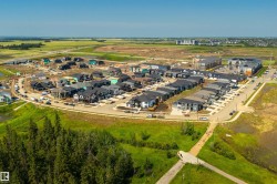 Aerial perspective of a developing residential community featuring a variety of housing types, including single-family homes and multi-story apartment buildings - 
