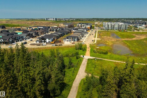 Expansive development area featuring a collection of contemporary homes with dark roofs, mature evergreen trees, and paved roadways - 323 Rankin Drive, St. Albert, AB - Outdoor With View