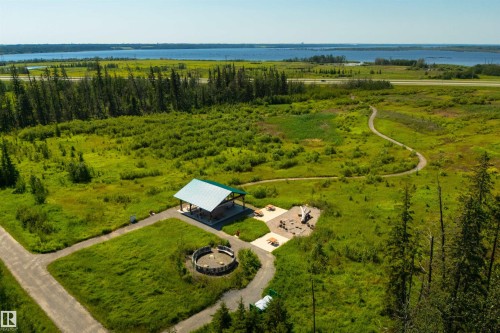 Open-air pavilion with a green metal roof, surrounded by natural landscaping and paved pathways - 323 Rankin Drive, St. Albert, AB - Outdoor With Body Of Water With View
