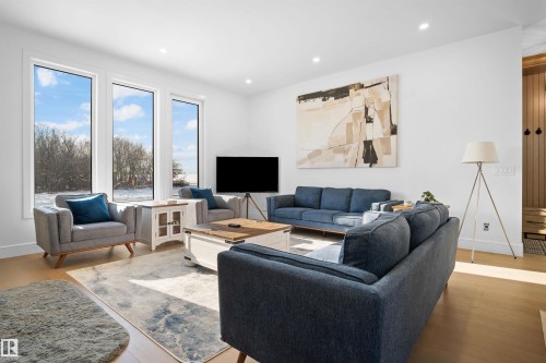 Bright living area featuring wood-finish flooring and recessed lighting - 12304 62 Ave Nw, Edmonton, AB - Indoor Photo Showing Living Room