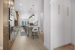 Modern kitchen featuring light wood-finish flooring, recessed lighting, and a vaulted ceiling - 