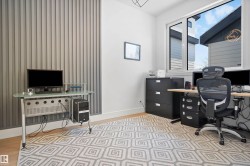 Bright room featuring a large window, light wood-finish flooring, and a textured accent wall with vertical paneling - 