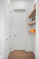 White interior door with brushed nickel hardware, flanked by a second white door and built-in floating shelves - 