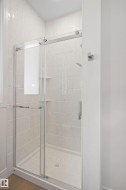 Enclosed shower stall featuring clear glass sliding doors and a white subway tile surround - 