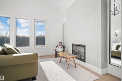 Vaulted ceiling with recessed lighting, three large windows, modern fireplace, and light wood-finish flooring - 