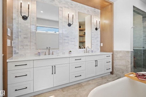 Double vanity with white cabinetry and matte black hardware, featuring dual rectangular sinks and a light-toned countertop - 12304 62 Ave Nw, Edmonton, AB - Indoor Photo Showing Bathroom