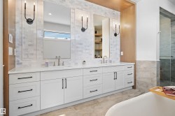 Double vanity with white cabinetry and matte black hardware, featuring dual rectangular sinks and a light-toned countertop - 