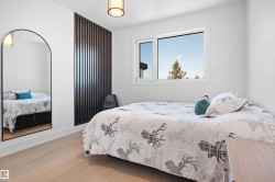 Light-toned wood-finish flooring complements the white walls and modern overhead lighting fixture - 