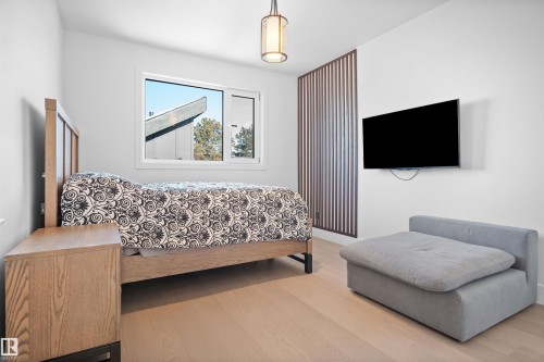 Bright room featuring wood-finish flooring, a contemporary window, and a decorative slatted partition - 12304 62 Ave Nw, Edmonton, AB - Indoor Photo Showing Bedroom