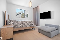 Bright room featuring wood-finish flooring, a contemporary window, and a decorative slatted partition - 