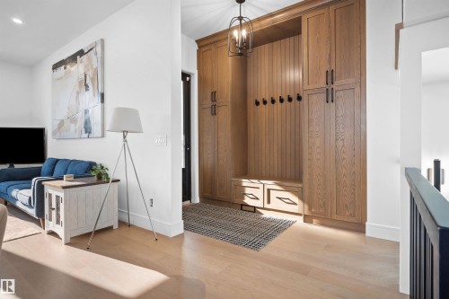 Built-in mudroom cabinetry with wood-finish paneling, integrated bench seating, and matte black hardware - 12304 62 Ave Nw, Edmonton, AB - Indoor Photo Showing Other Room