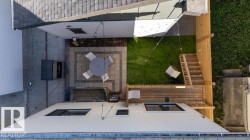 Backyard featuring a paver patio, artificial turf area, and a wooden deck - 