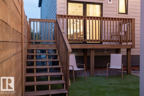 Rear exterior featuring a wooden deck with railing, stairs, and a sliding glass door - 12304 62 Ave Nw, Edmonton, AB - Indoor Photo Showing Other Room