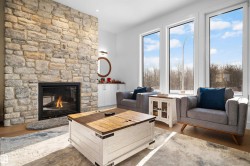 Stone veneer fireplace with an integrated firebox, accompanied by built-in white cabinetry - 