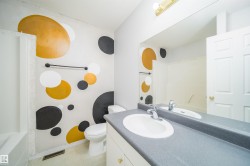 Bathroom featuring a built-in vanity with a single basin sink and a large mirror - 