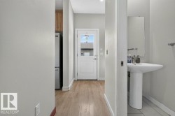 Entryway featuring a white paneled door with an upper glass pane, wood-finish flooring, and light gray walls - 