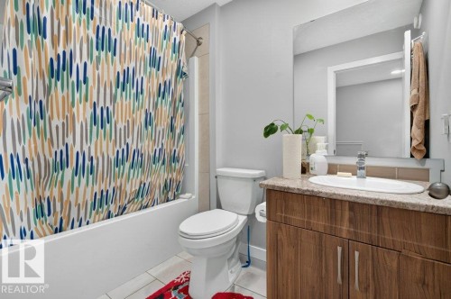 Bathroom featuring a wood-finish vanity with an oval undermount sink, a tiled backsplash, and a large wall-mounted mirror - 43 Sienna Boulevard, Fort Saskatchewan, AB - Indoor Photo Showing Bathroom