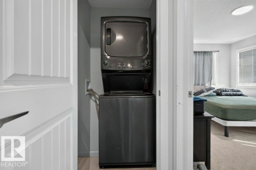 Dedicated laundry area featuring a stacked washer and dryer unit - 43 Sienna Boulevard, Fort Saskatchewan, AB - Indoor Photo Showing Laundry Room