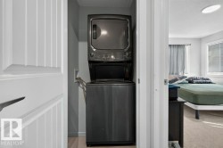Dedicated laundry area featuring a stacked washer and dryer unit - 