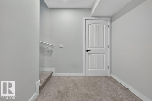 White paneled door with matte black hardware, set against light gray walls with white baseboards - 43 Sienna Boulevard, Fort Saskatchewan, AB - Indoor Photo Showing Other Room