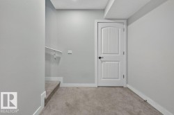 White paneled door with matte black hardware, set against light gray walls with white baseboards - 