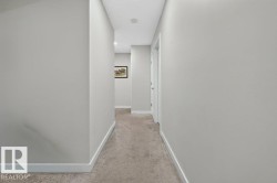 Neutral toned walls with white trim throughout, featuring recessed lighting and carpeted flooring - 