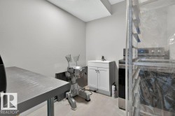 Compact utility space featuring a built-in sink cabinet, stainless steel countertop, and light wood-finish flooring - 