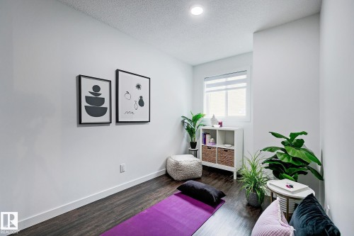 Room featuring dark wood-finish flooring, white walls, and a recessed ceiling light - 19F Meadowlark Village Nw, Edmonton, AB - Indoor