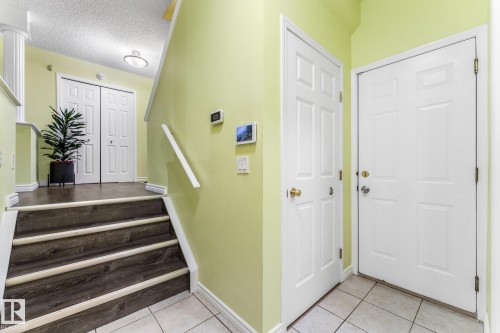 Garage door on the far right, then basement entrance door to the left. The stairs lead up to main floor, living room, kitchen, and dining room. Behind this position in the photo is a two piece bathroom and laundry room. - 13148 151 Avenue Nw, Edmonton, AB - Indoor Photo Showing Other Room