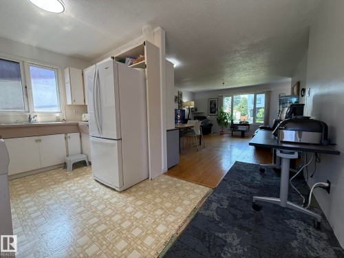 Kitchen with white cabinetry, double basin sink, and patterned flooring - 10837 155 Street Nw, Edmonton, AB - Indoor Photo Showing Kitchen With Double Sink
