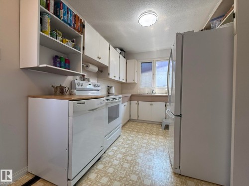 Kitchen featuring white cabinetry, a built-in dishwasher, and a white electric range - 10837 155 Street Nw, Edmonton, AB - Indoor Photo Showing Kitchen
