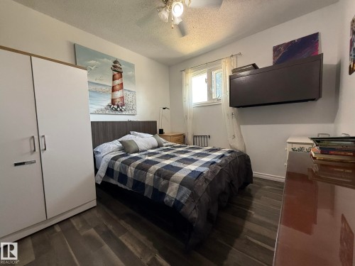 Bedroom featuring wood-finish flooring, a ceiling fan with integrated lighting, and a window with white trim - 10837 155 Street Nw, Edmonton, AB - Indoor Photo Showing Bedroom