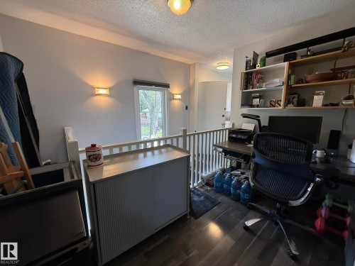 Upper-level area featuring dark wood-finish flooring and a white railing - 10837 155 Street Nw, Edmonton, AB - Indoor Photo Showing Office