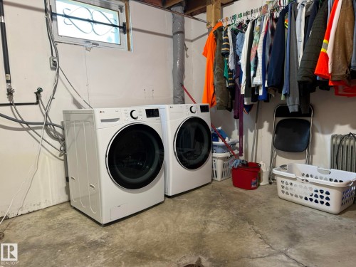 Laundry area featuring a concrete floor, exposed ceiling joists, and a window with security bars - 10837 155 Street Nw, Edmonton, AB - Indoor Photo Showing Laundry Room