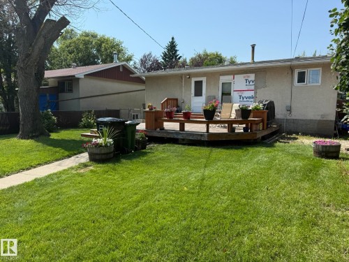 Backyard featuring a wooden deck, a well-kept lawn, and mature trees - 10837 155 Street Nw, Edmonton, AB - Outdoor With Deck Patio Veranda