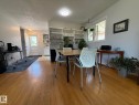 Hardwood flooring extends throughout this interior space, featuring a built-in shelving unit and a white-framed window - 10837 155 Street Nw, Edmonton, AB  - Indoor Photo Showing Dining Room 