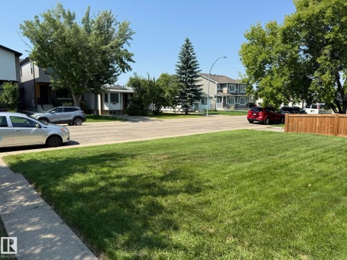 Expansive front lawn with mature shade trees, bordered by a sidewalk and street - 10837 155 Street Nw, Edmonton, AB - Outdoor