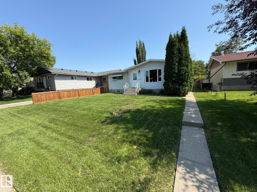 White siding residence with a mature front yard, featuring a concrete walkway and established trees - 10837 155 Street Nw, Edmonton, AB - Outdoor