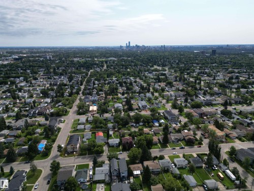 Expansive aerial perspective showcasing a residential area with extensive tree coverage and a distant city skyline - 10837 155 Street Nw, Edmonton, AB - Outdoor With View