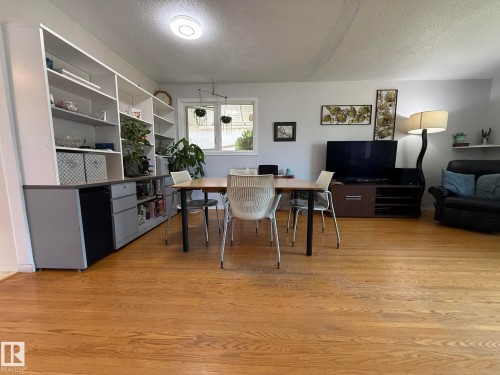 Hardwood flooring extends throughout this room, featuring a built-in shelving unit with lower cabinetry - 10837 155 Street Nw, Edmonton, AB - Indoor
