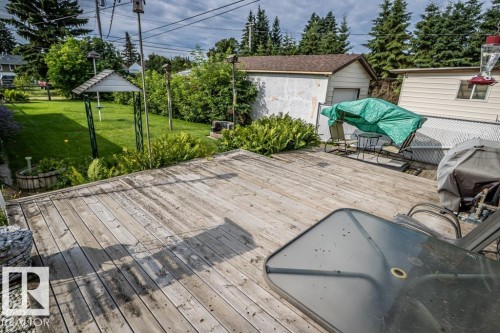 Expansive wood-finish deck extending to a manicured lawn area - 5009 47 Ave, St. Paul Town, AB - Outdoor With Deck Patio Veranda